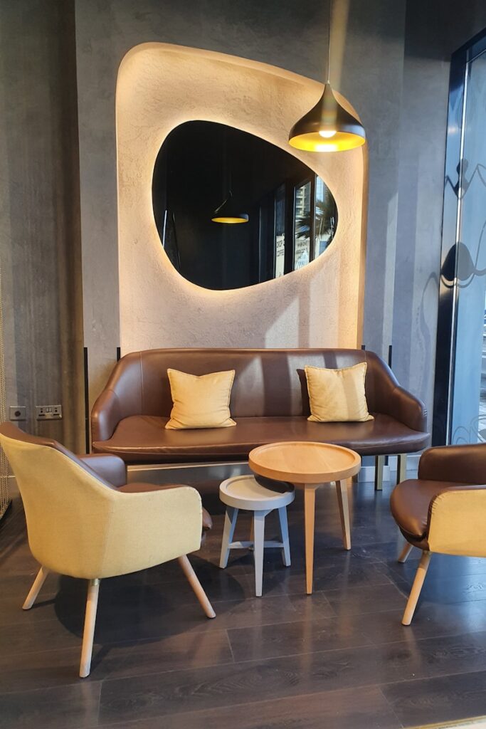 a living room with a couch, chairs and a mirror